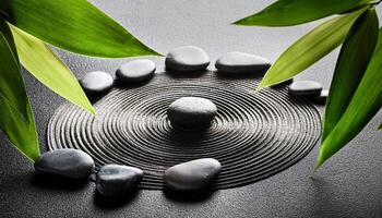 An arrangement of black stones in a circular pattern with green bamboo leaves, evoking harmony, meditation, and calmness. photo