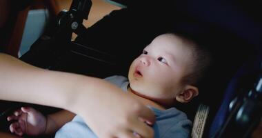 Hand of Young mother happily playing with little boy lying in baby stroller in a cafe. Family enjoying happy time together. Happy lifestyle. video