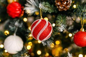 A close-up of red and silver glittering ornaments on a branch of a Christmas tree photo