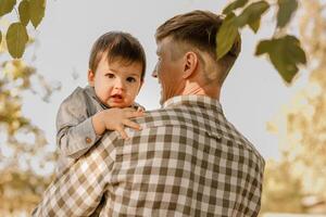Portrait of loving father and his one years old son walking and playing outdoors photo