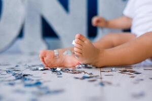 One years old child's feet on high chair while he is eating at kitchen dinner table. photo