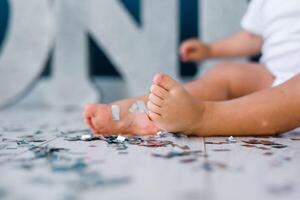 One years old child's feet on high chair while he is eating at kitchen dinner table. photo
