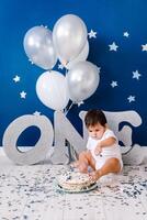 curious baby boy poking finger in his first birthday cake photo