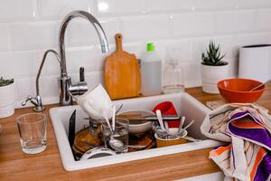 Clutter, dirty dishes by the sink in the white kitchen photo