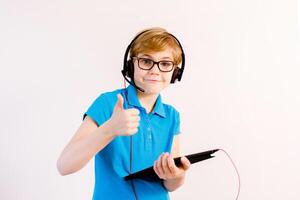 Little boy in glasses using a tablet computer with a light background photo
