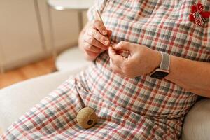 Hands of a senior woman crocheting captured in close-up photo