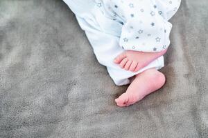 Newborn baby on a white blanket - tiny baby feet closeup photo