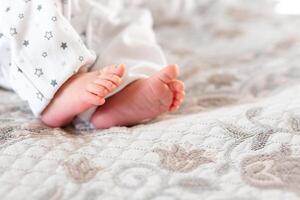 Newborn baby on a white blanket - tiny baby feet closeup photo