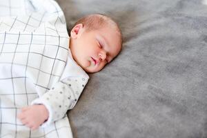 Close-up portrait of adorable baby boy sleeping in bed, 1 year old baby concept photo