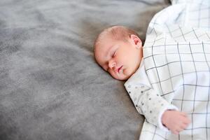 Baby boy sleeping first days of life. Cute little newborn child sleeping peacefully photo