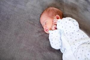 Baby boy sleeping first days of life. Cute little newborn child sleeping peacefully photo