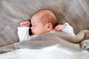 Peaceful baby lying on a bed while sleeping in a bright room. photo