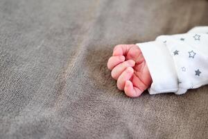 Newborn baby with tiny hand in focus photo