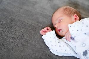 Baby boy sleeping first days of life. Cute little newborn child sleeping peacefully photo