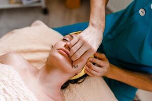 Facial massage with gouache stone in a beauty salon photo