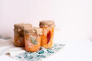 three jars of sauerkraut and carrots in its own juice. traditional home-made, fermented dish of Russia and Germany. photo