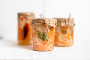 three jars of sauerkraut and carrots in its own juice. traditional home-made, fermented dish of Russia and Germany. photo