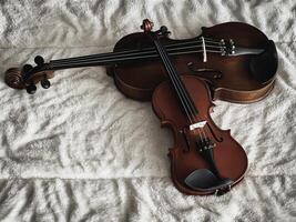 Two different size of violins put on soft cotton cloth, photo