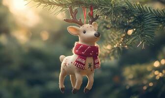 A white deer ornament with a red scarf is hanging from a tree photo