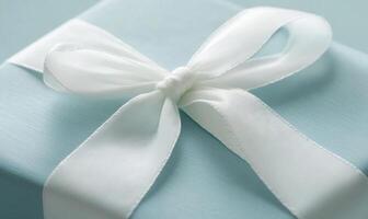 A blue box with a white bow on top of it photo