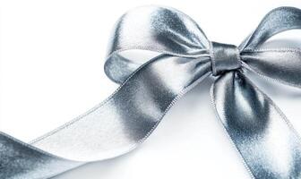 A silver ribbon bow is shown on a white background photo