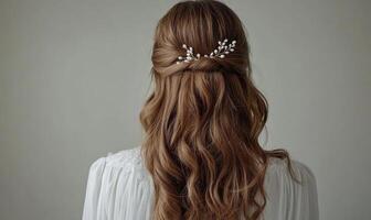 A woman with long brown hair is wearing a flowery hair accessory photo