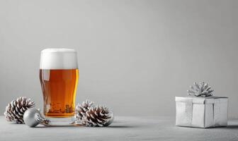 A glass of beer is on a table next to a box of pine cones photo