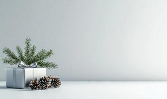 A silver box with a bow on top of it is surrounded by pine cones photo