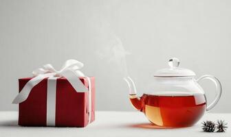 A red box with a white bow sits on a table next to a teapot photo