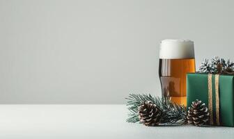 A green box with a ribbon sits on a table next to a glass of beer photo