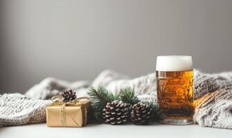 A glass of beer sits on a table next to a box with a ribbon on it photo