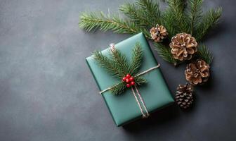 A green box with a red ribbon and a green pine tree on top of it photo