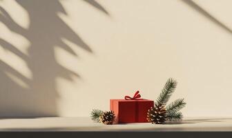 A red box with a bow on top of a table with pine cones photo