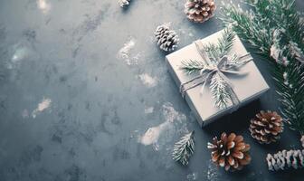 A white box with pine cones and a ribbon on top of a grey background photo