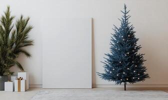 A blue Christmas tree stands in front of a white wall photo