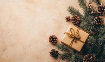 A box with a gold ribbon sits on a table with pine cones photo