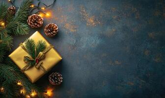 A gold box with a bow on top of a blue background with pine cones and lights photo