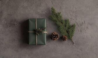 A green box with a ribbon on it sits on a grey surface photo