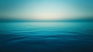 Calm Ocean Surface with a Hazy Sky in the Distance photo