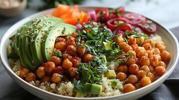 Beautifully plated vegan buddha bowl recipe featuring quinoa avocado slices roasted chickpeas and a colorful array of vegetables arranged in a harmonious pattern on a white plate photo
