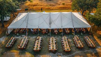 Top down view of outdoor event with tables and chairs under a large tent set for a celebration white isolated background photo