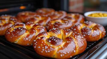Soft pretzels baking the oven topped with coarse salt and accompanied by a bowl of mustard and fresh pretzel dough on the side creating a savory and satisfying snack perfect for any occasion photo