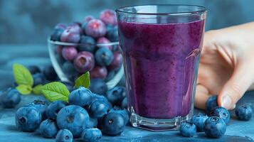 Glass of antioxidantrich blueberry juice with a handful of blueberries cut out on an isolated simple minimalist background photo