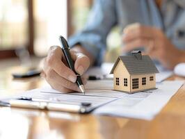 Customer and landlord completing rental agreement, focus on agreement papers and signatures, photo