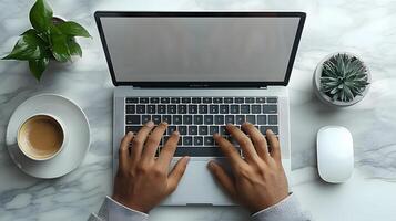 Close-up of hands typing on a laptop at a modern desk, with a cup of coffee and a small plant nearby. photo