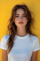 Top half body image of a young woman in a white t-shirt against a yellow blur backdrop, suited for clothing brand promotion. photo