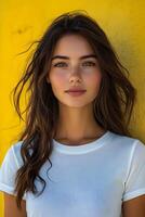Portrait of a young woman in a white t-shirt against a yellow blur backdrop, top half body shot suitable for clothing brand showcases. photo