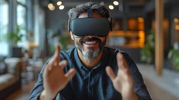 A businessman with a cheerful expression wearing virtual reality goggles, sitting at his desk in a modern office, making creative hand gestures. photo