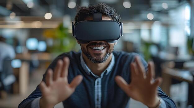Smiling professional man at his desk, using virtual reality goggles to explore a digital world, making dynamic hand movements in a modern office. photo