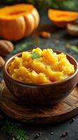 Steaming bowl of pumpkin puree garnished with fresh herbs on rustic wooden table photo